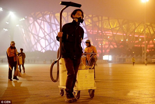 Walking around Beijing with an industrial vacuum, artist Brother Nut also wears a face mask to protect himself